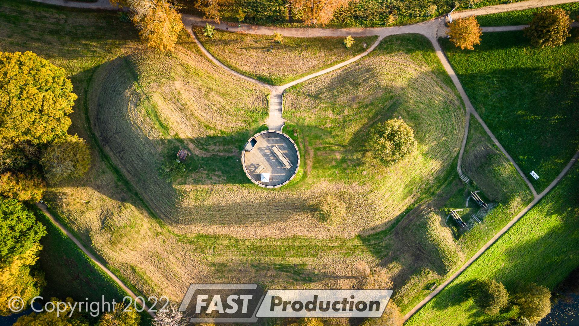 Dronefoto lodret ned over Det Hvide Tårn omgivet af græsklædte volde og stier